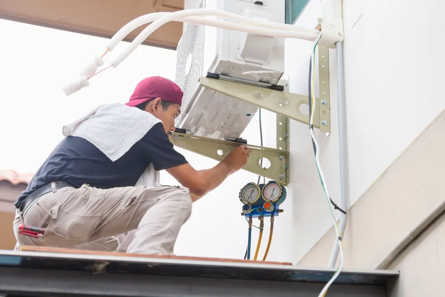 AC technician installing an indoor unit in a property on the Cote d'Azur