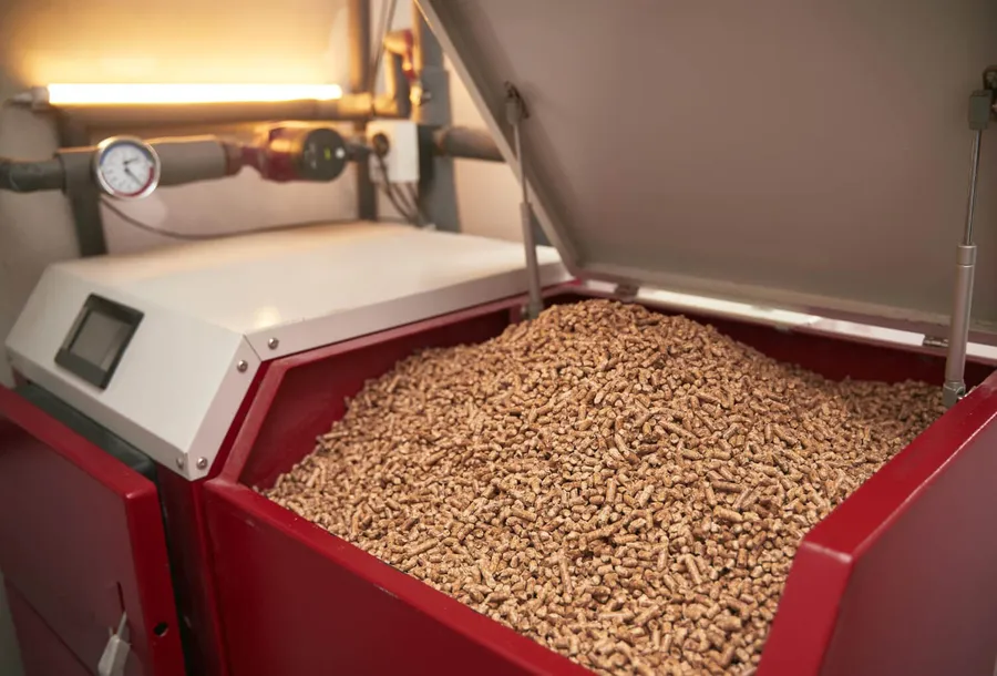 Wood pellets in an open pellet boiler hopper showing the fuel storage system