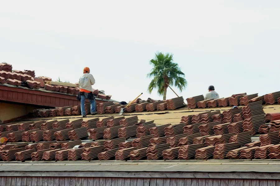 Roofer laying terracotta roof tiles on a Cote d'Azur house