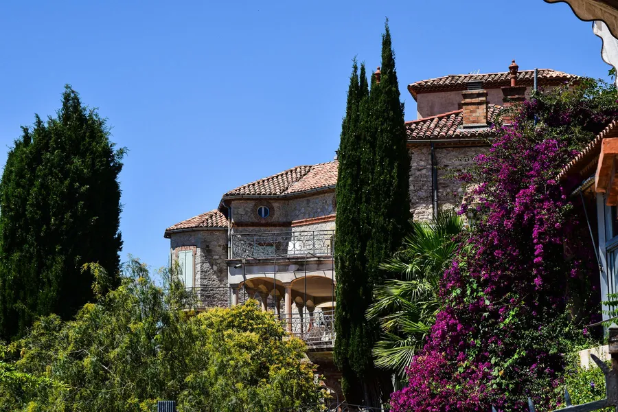 Restored stone villa with terracotta roofs, bougainvillea and cypress trees